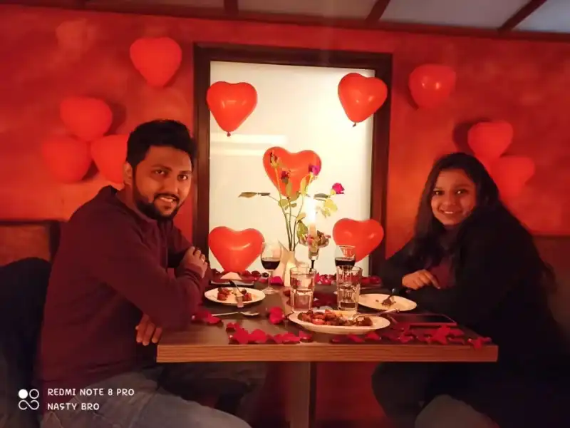 Couple dining under heart balloons honeymoon
