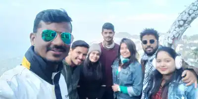 Group selfie with spectacular mountain ranges in the background during North East tour