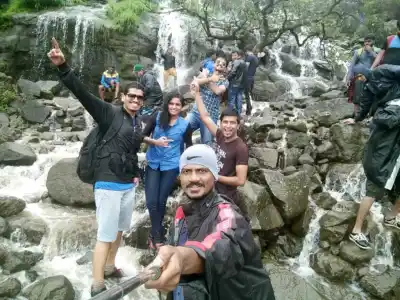 Tour Group selfie in front of waterfalls on Visapur Fort Trek