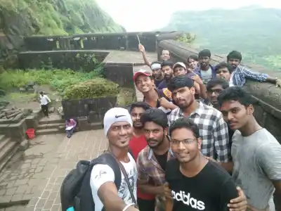 Tour Group selfie on stone wall of Lohagad Fort Trek